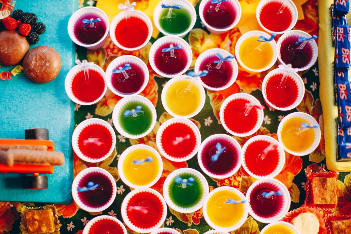 Vasitos individuales de gelatina proteica transparente con textura firme sobre una mesa de madera