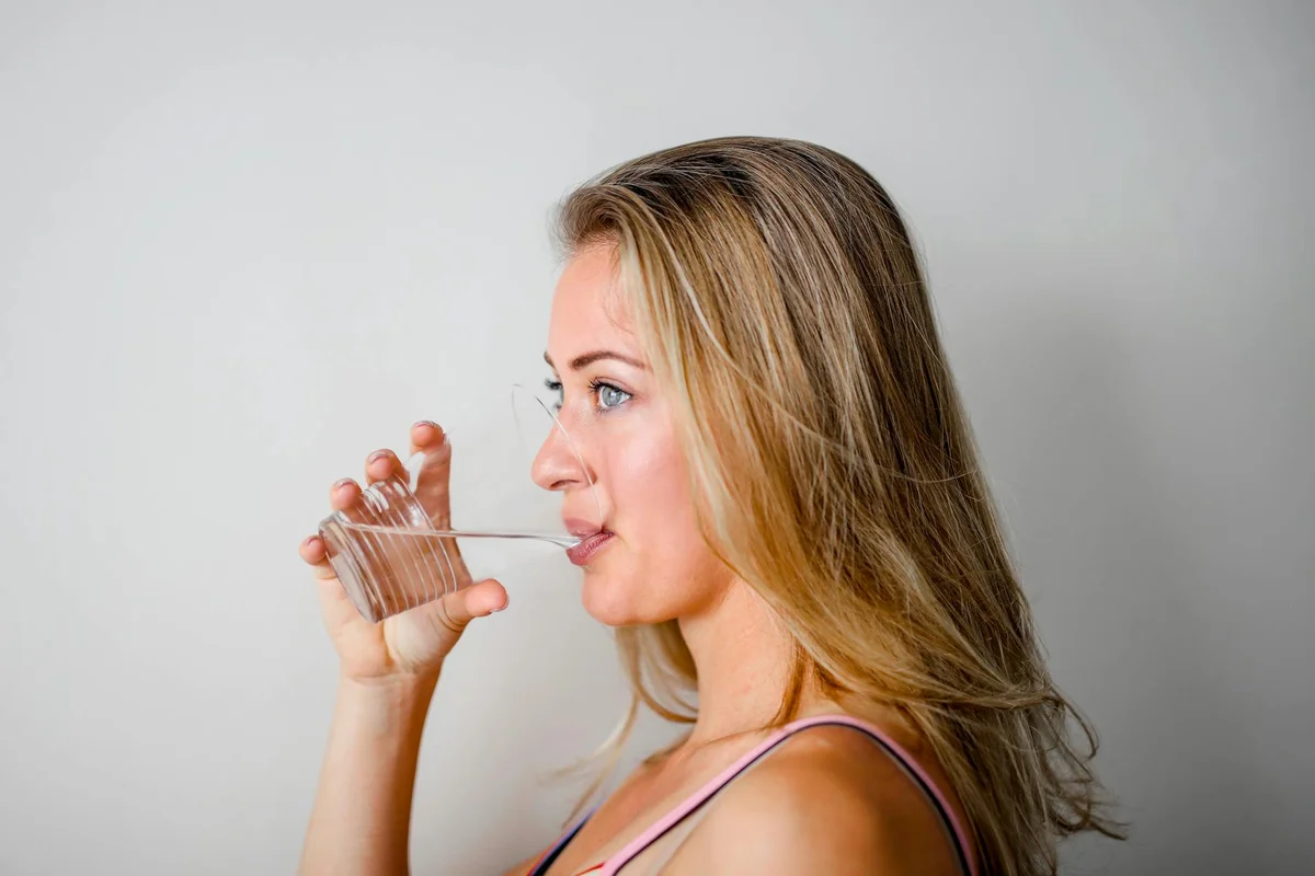 Mujer bebiendo agua, hábito de hidratación saludable