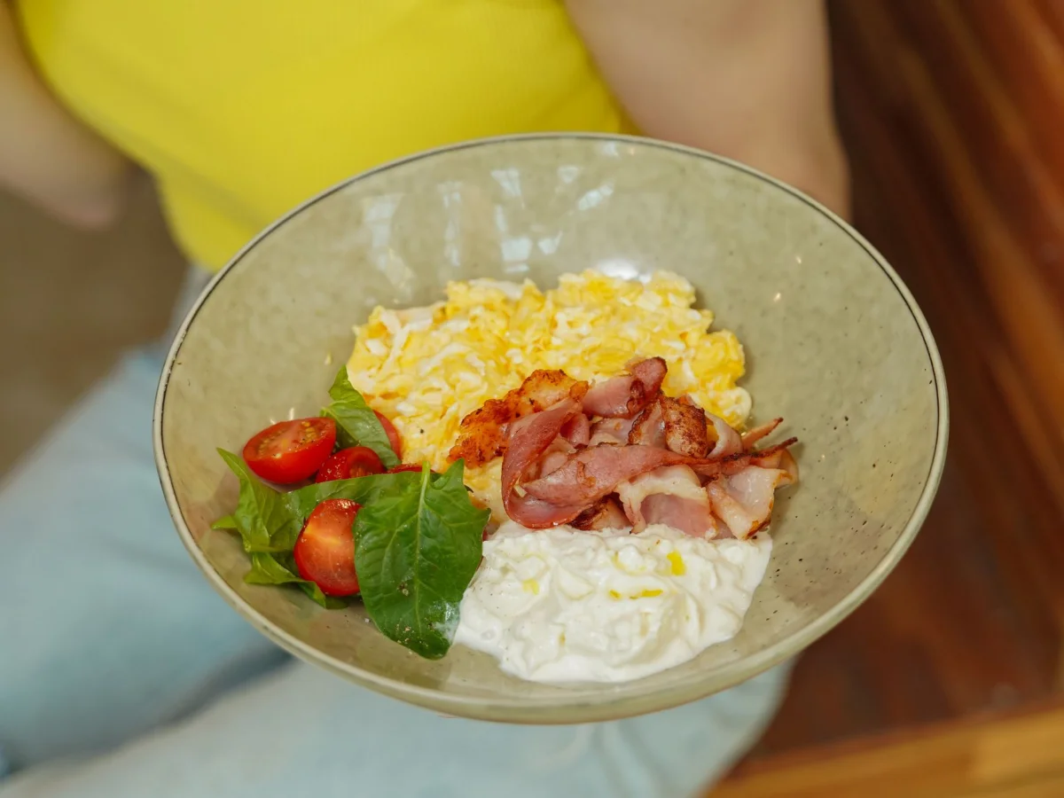 Bol de salmorejo rojo brillante con huevo duro picado y jamón serrano por encima